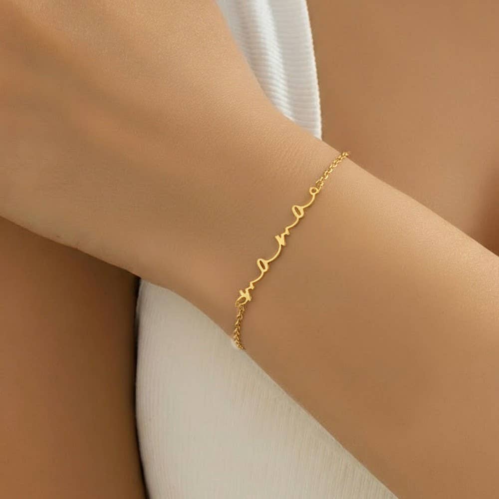Close-up of the Everly gold Mama script bracelet worn on the wrist
