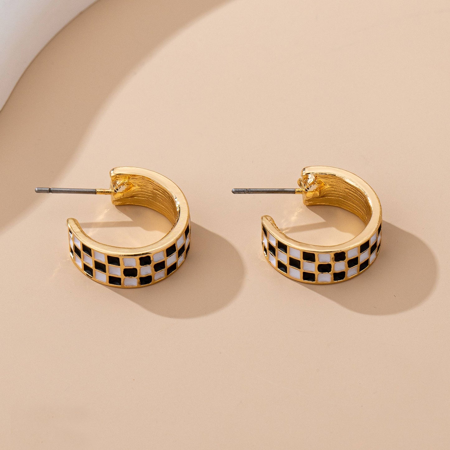 Sloane checkered huggie hoop earrings showing the gold-tone backs and titanium posts