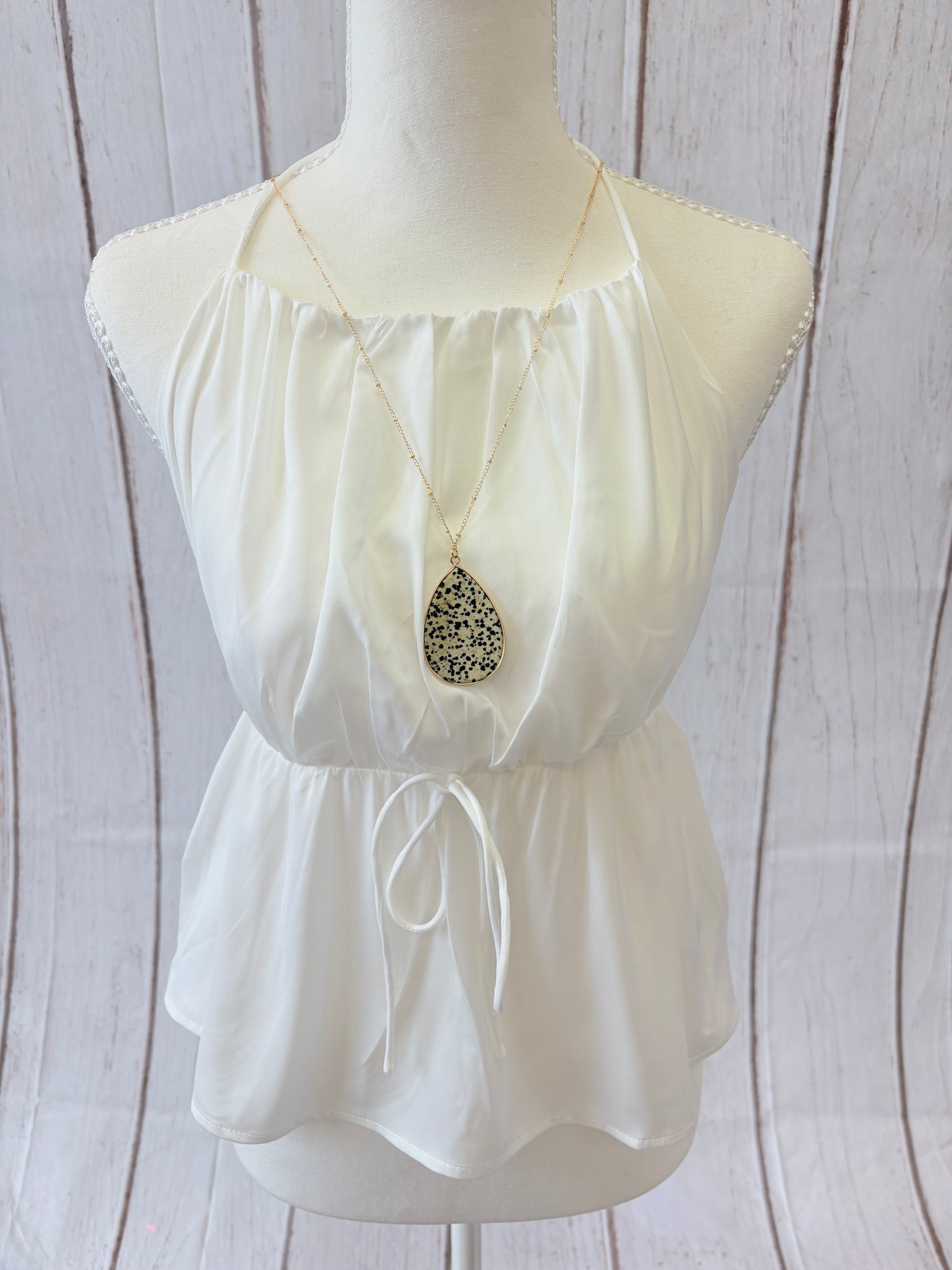 White strapless dress with a bow on a mannequin against a wooden background
