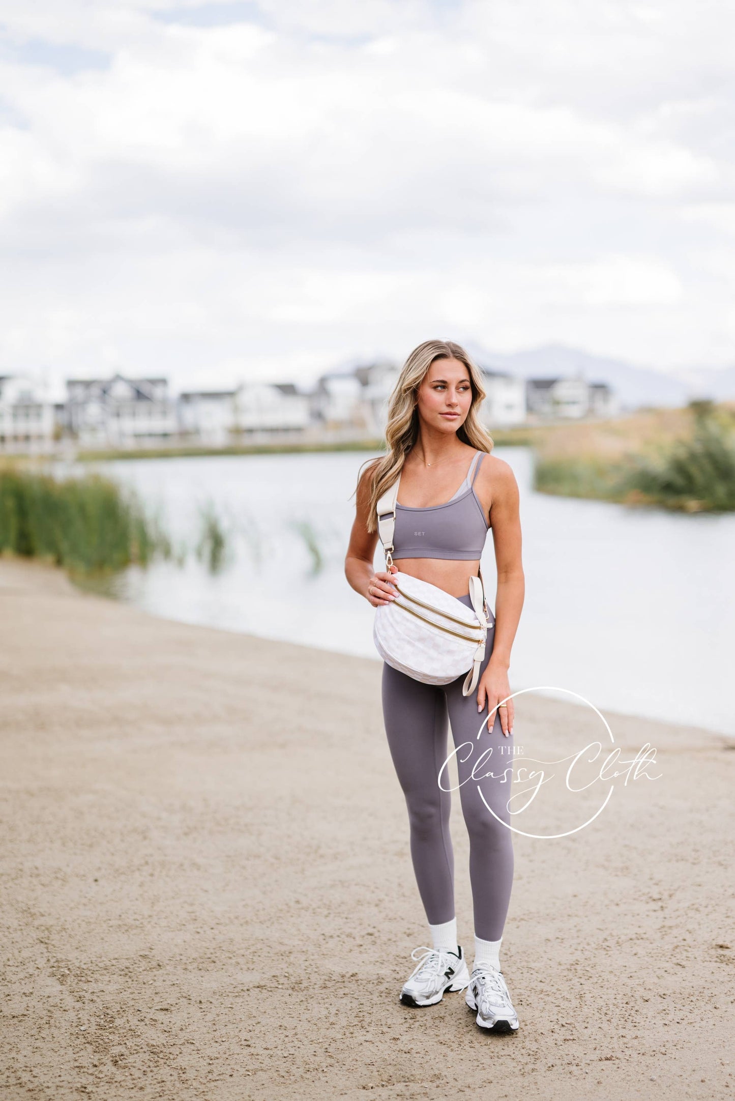 Woman in athletic wear standing by a lake with 'Classey Cloe' branding.