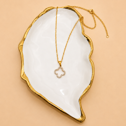Camille gold crystal clover pendant necklace displayed on a white shell
