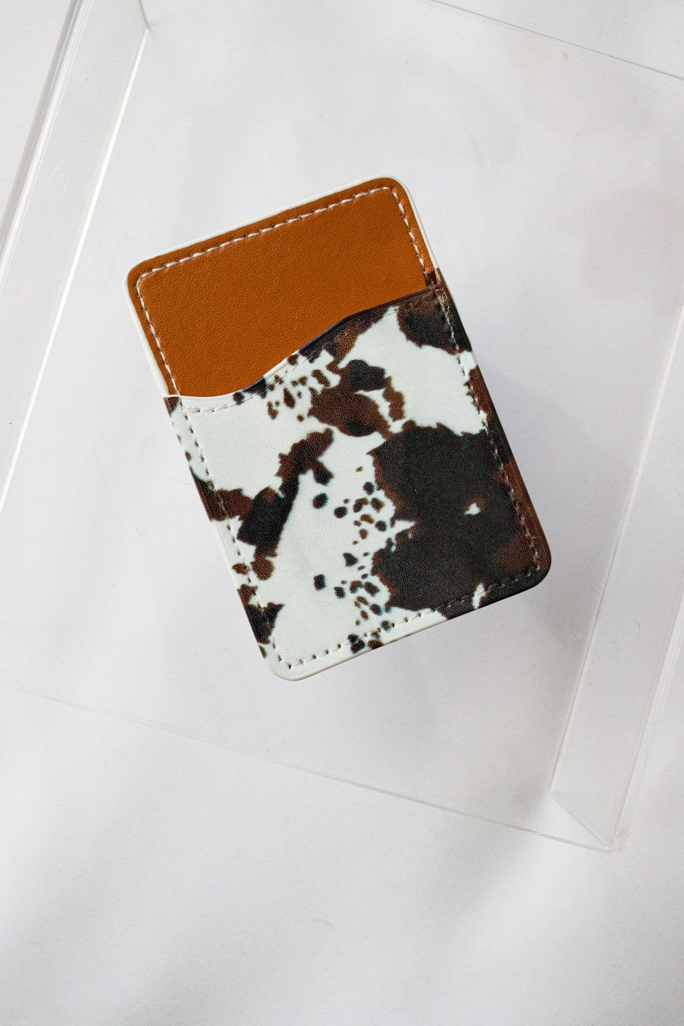 Cardholder with cow print design on a white background