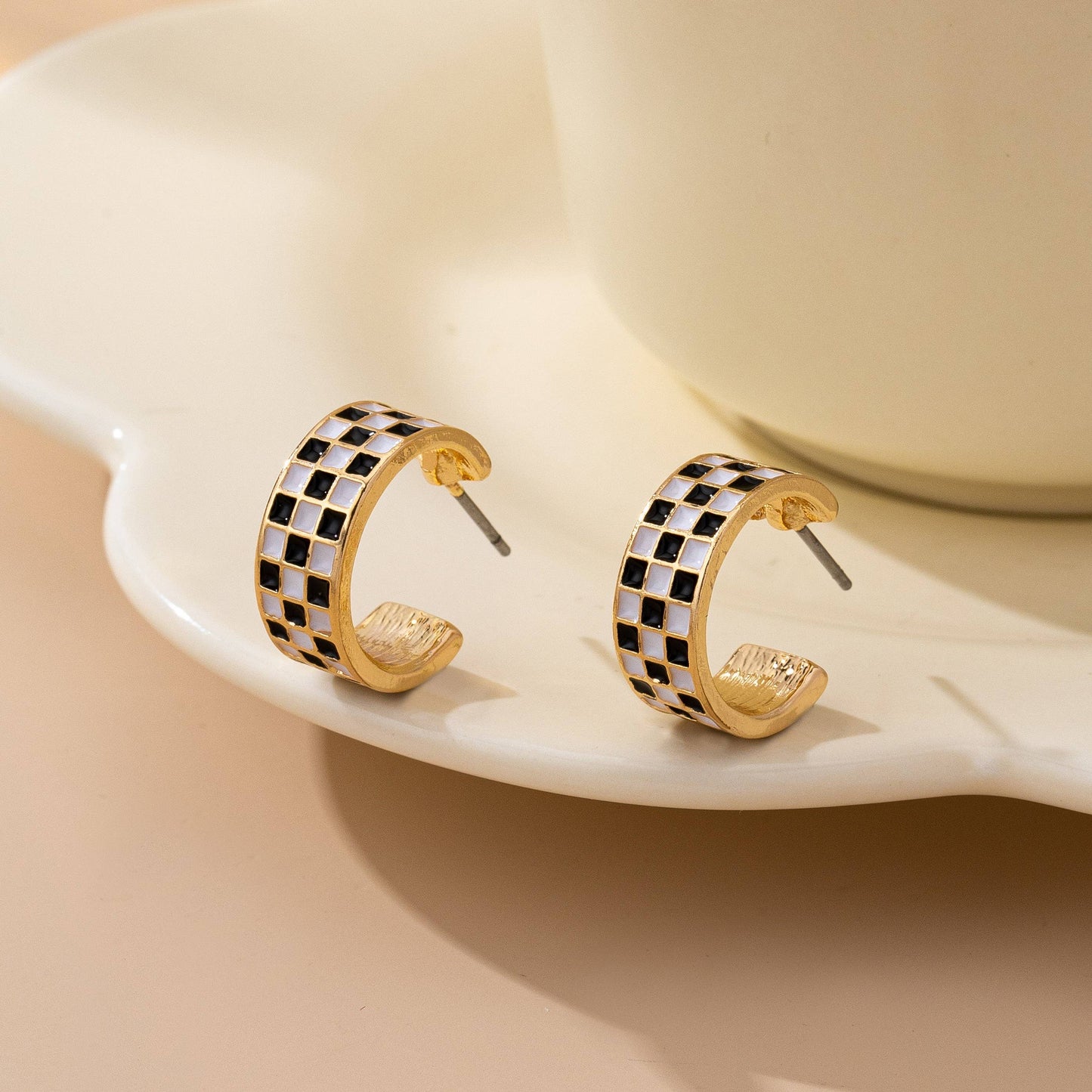 Pair of Sloane gold-tone huggie hoop earrings with black-and-white checkerboard enamel
