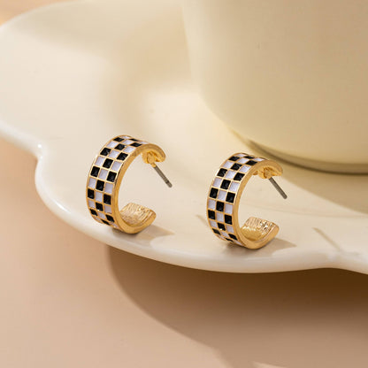 Pair of Sloane gold-tone huggie hoop earrings with black-and-white checkerboard enamel
