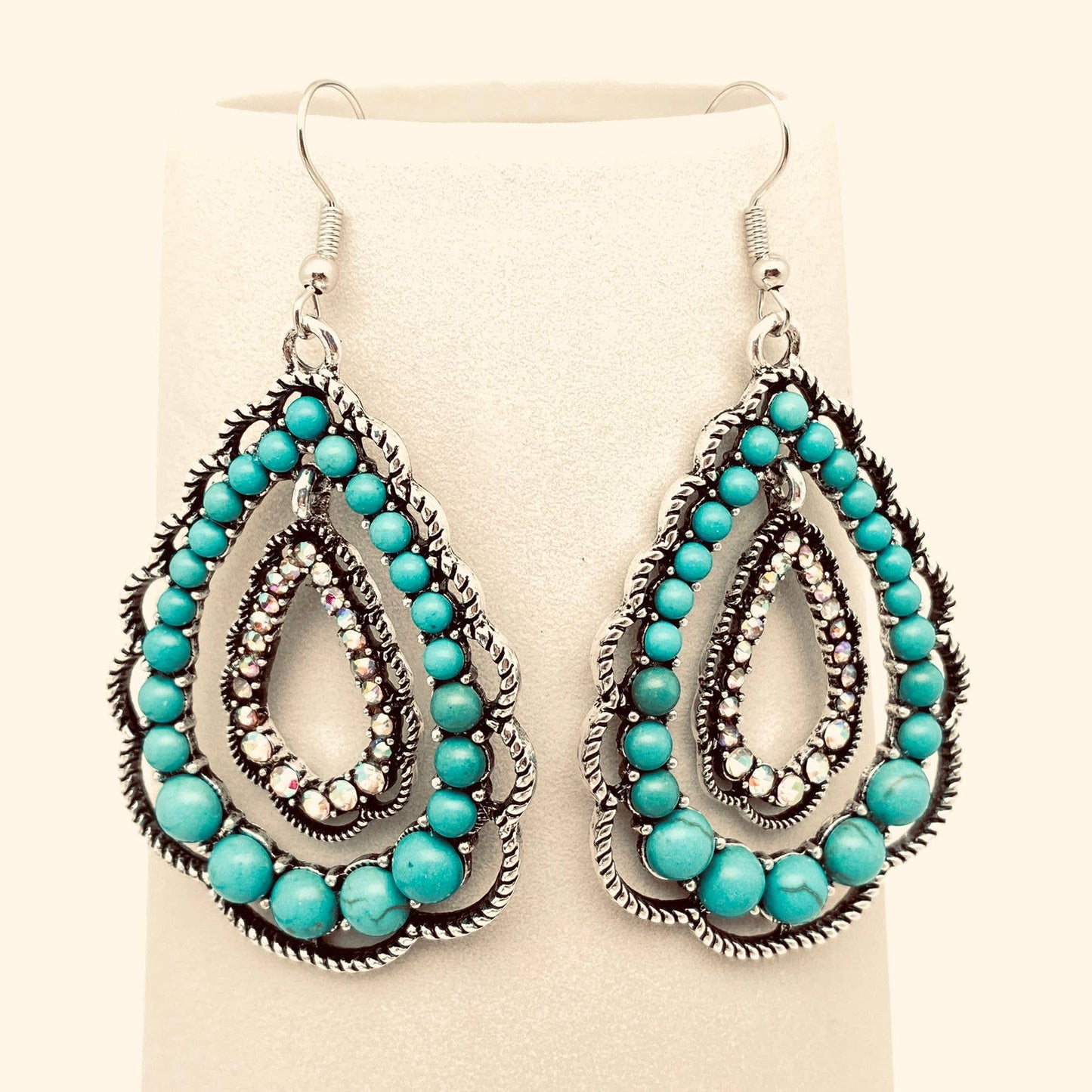 Turquoise beaded earrings on a beige background