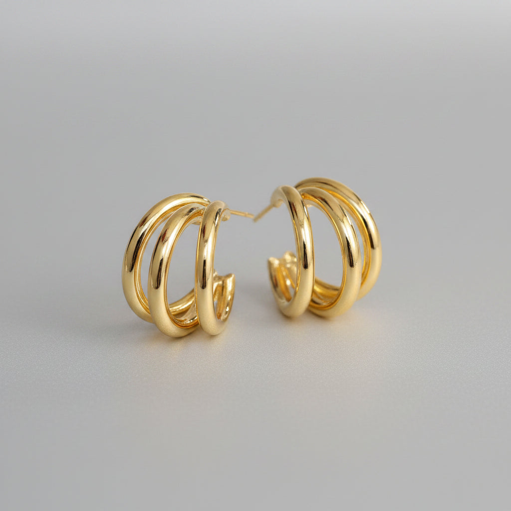 Gold hoop earrings on a beige background