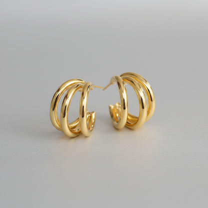Gold hoop earrings on a beige background