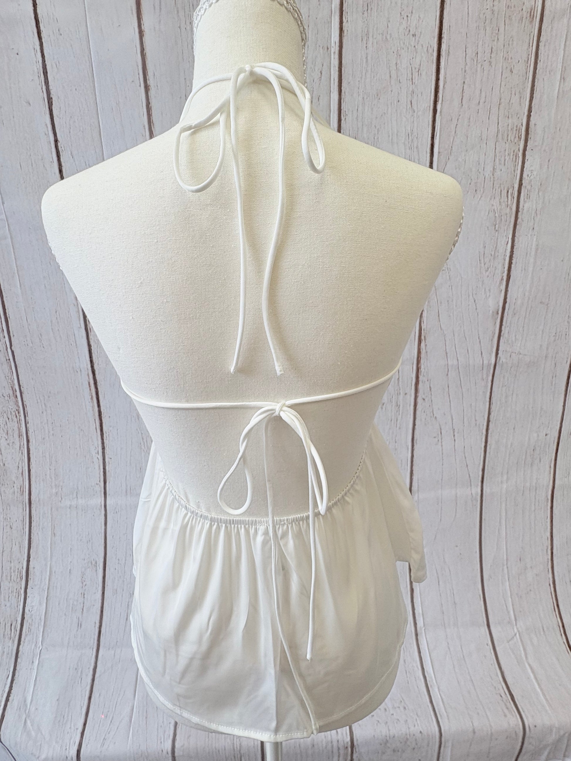 White strapless dress with a large bow on a wooden surface