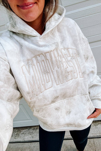 Woman wearing oversized white birch Midwest embroidered camo hoodie